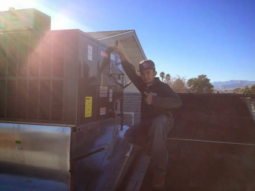 HVAC technician performing Air Duct Cleaning on a rooftop unit in Minnetonka